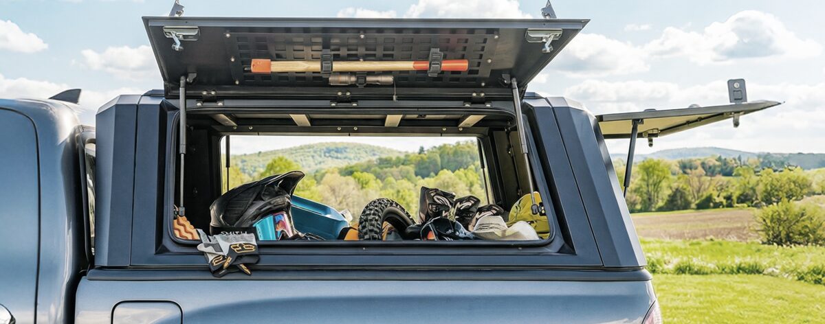 A pickup truck camper canopy held open by ARANA gas struts